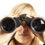 Young woman looking through binoculars